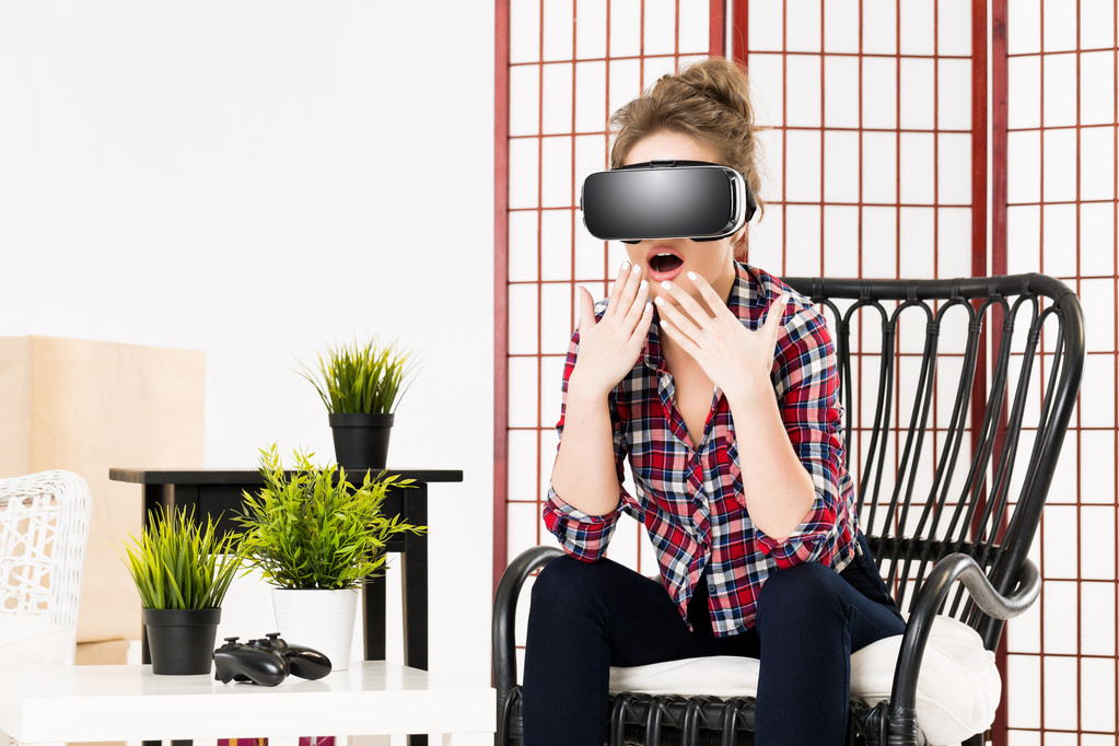 Woman playing VR while sitting in chair